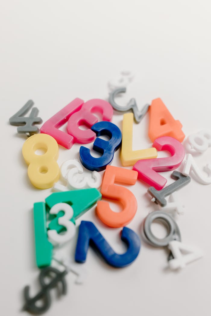 heros-img Vibrant plastic numbers scattered on a white background, ideal for educational themes.